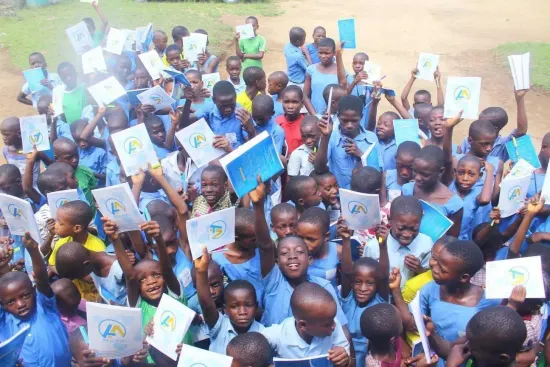 Students raise their new notebooks, One Child, One Pen, One Book 2023