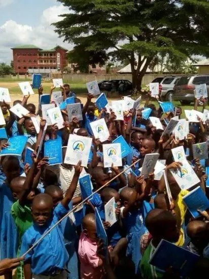 Students raise their new notebooks, One Child, One Pen, One Book 2023