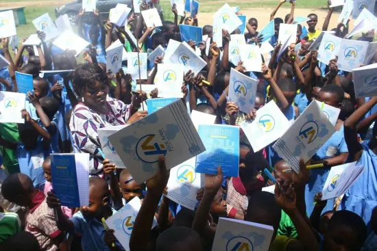Students raise their new notebooks, One Child, One Pen, One Book 2023