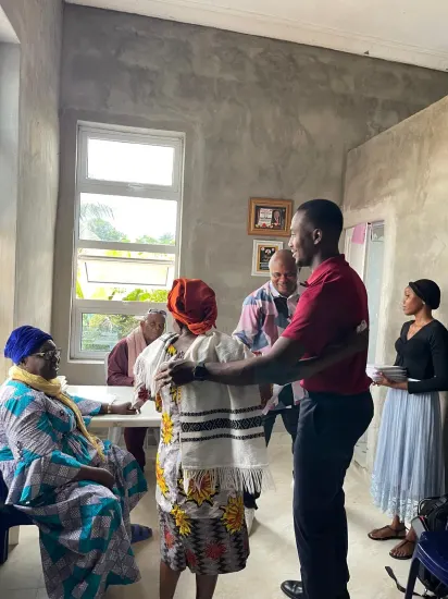 Pastor Joseph Ante with an older widow during a Widows Empowerment visit, Nigeria 2026